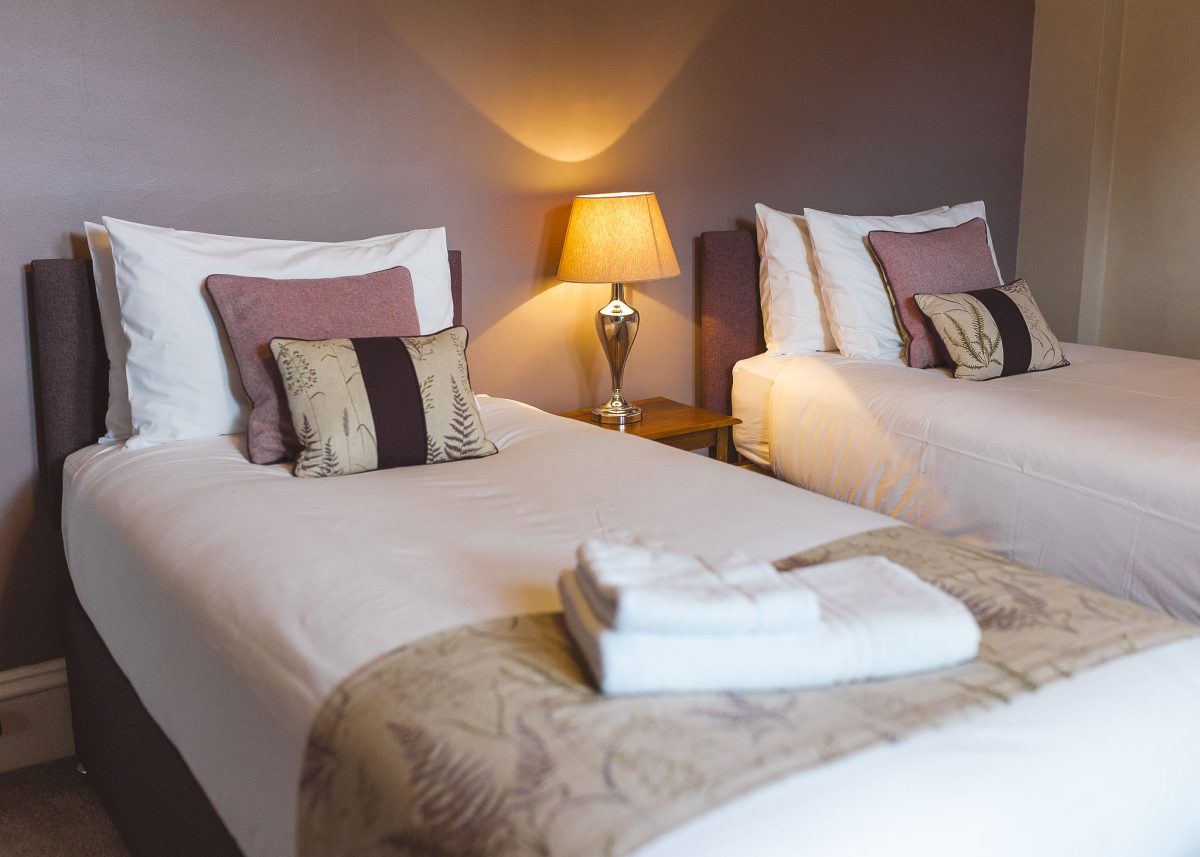 Twin bedroom at Potarch Lodge with two comfortable beds with ensuite bathroom