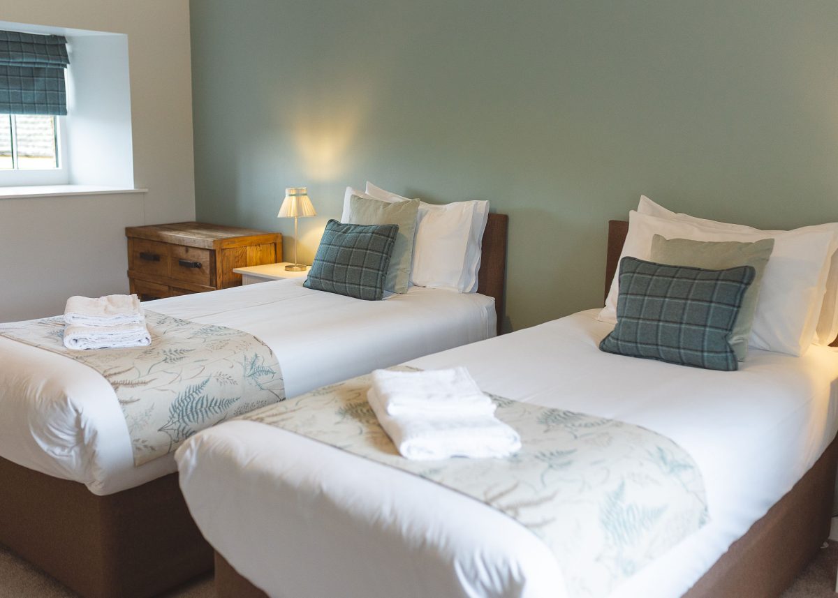 Twin bedroom at Potarch Lodge with two comfortable beds with ensuite bathroom