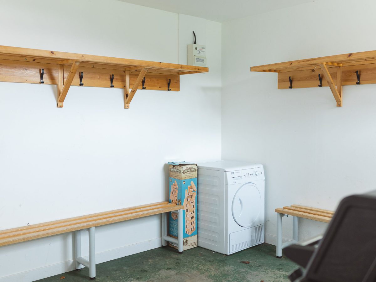 Potarch Lodge drying room with tumble-dryer and coat hooks for outdoor gear