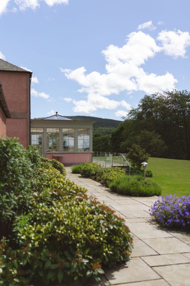 Ballogie House Orangery and back lawn with patio area extending around the back of the house in Spring/Summer